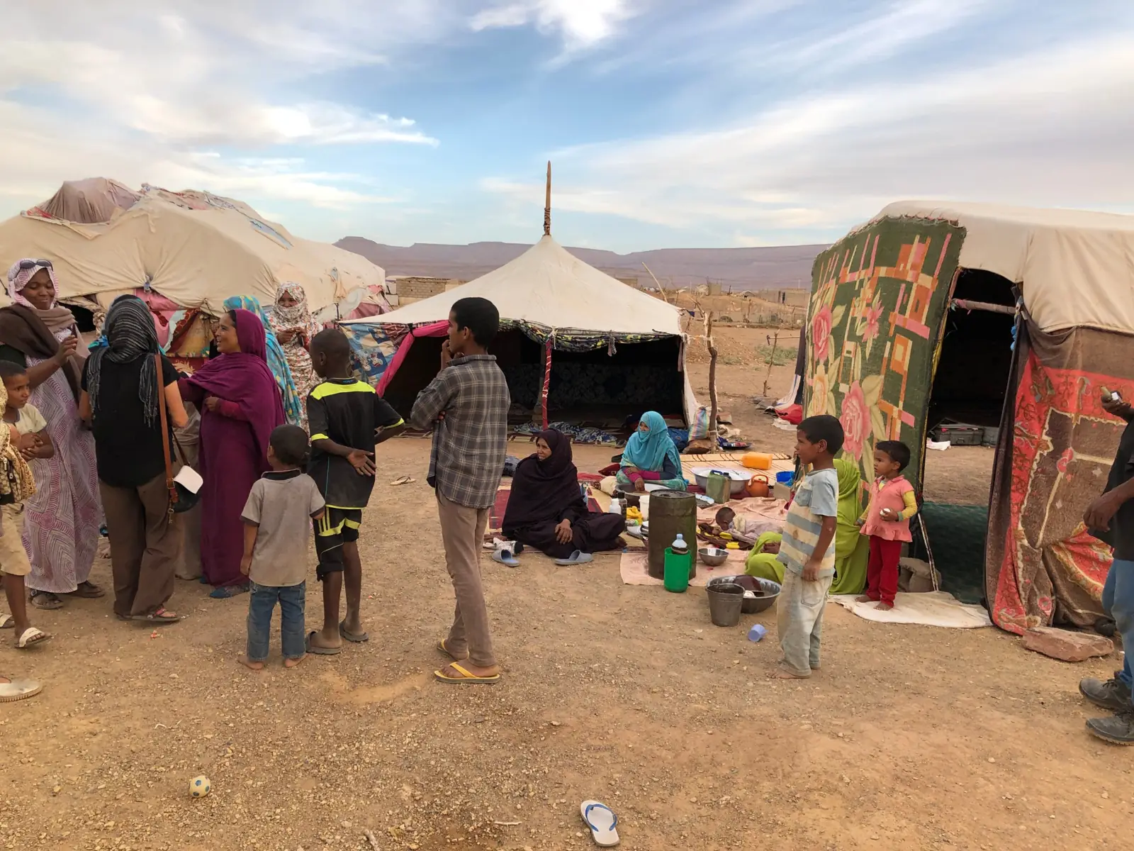 Donne e bambini tra le tende di un accampamento