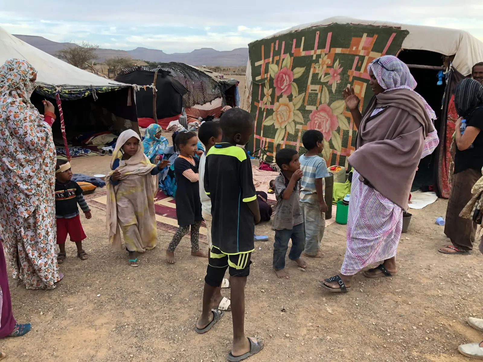 Bambini e donne davanti a una tenda decorata