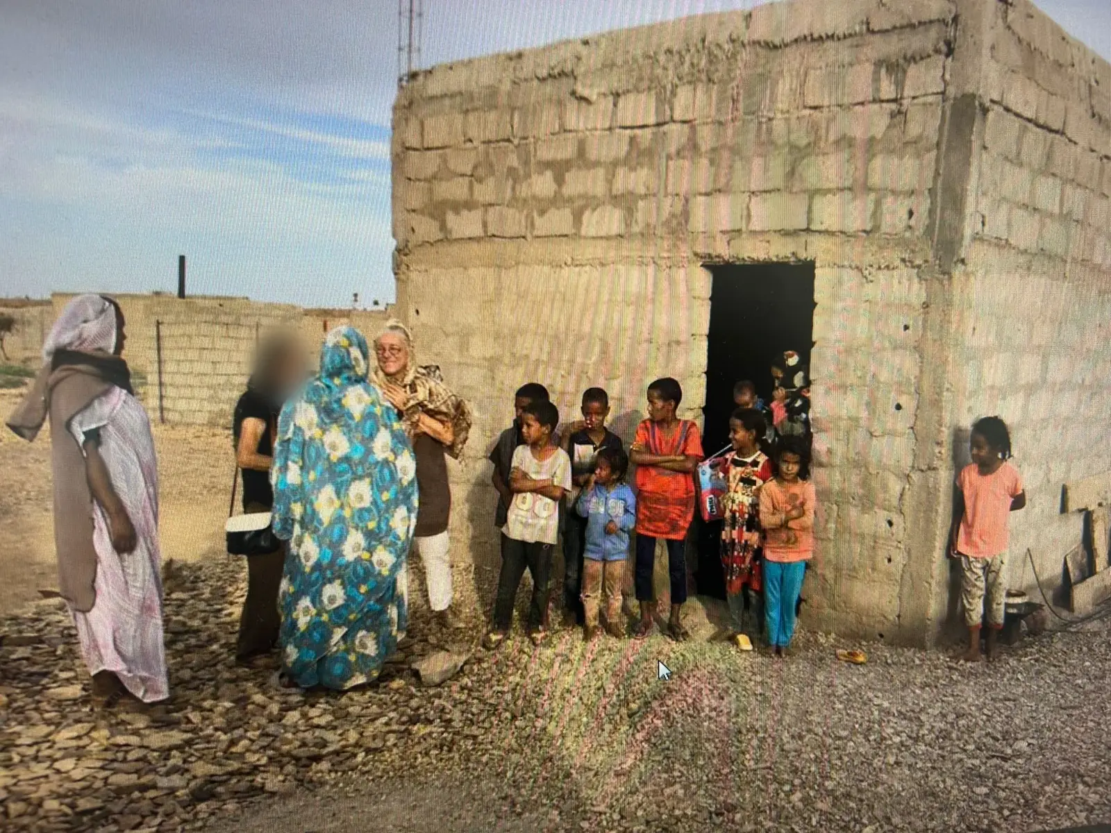 Barbara davanti alla prima casa costruita, con le famiglie
