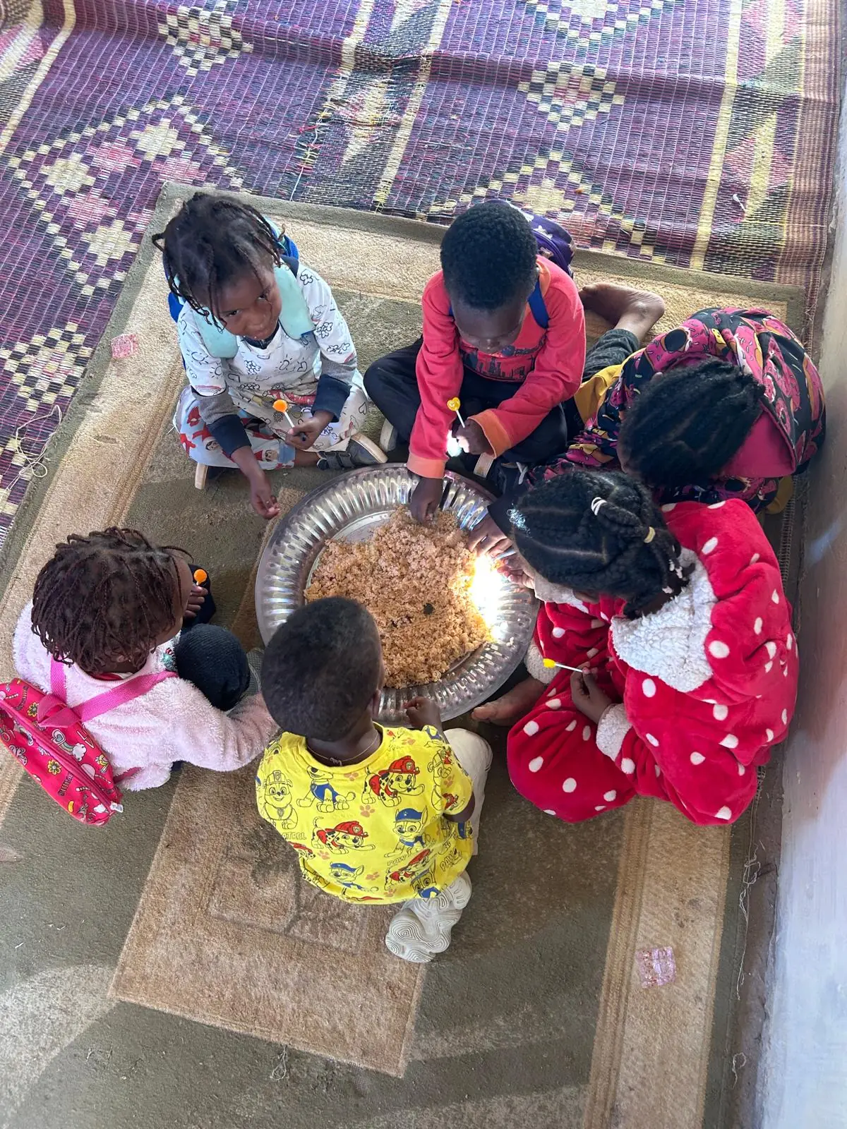 Bambini piccoli che mangiano insieme dal vassoio al refettorio